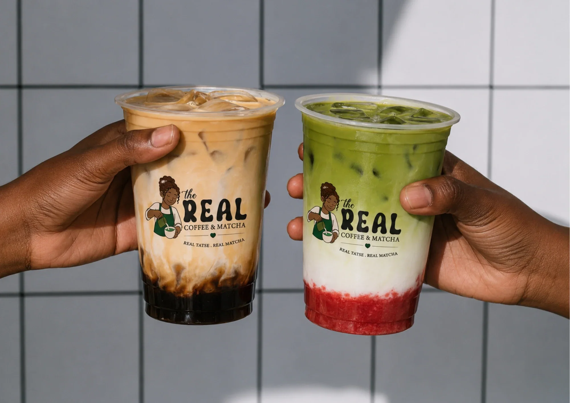 Deux boissons The Real, un latte glacé et un matcha, tenues à bout de bras